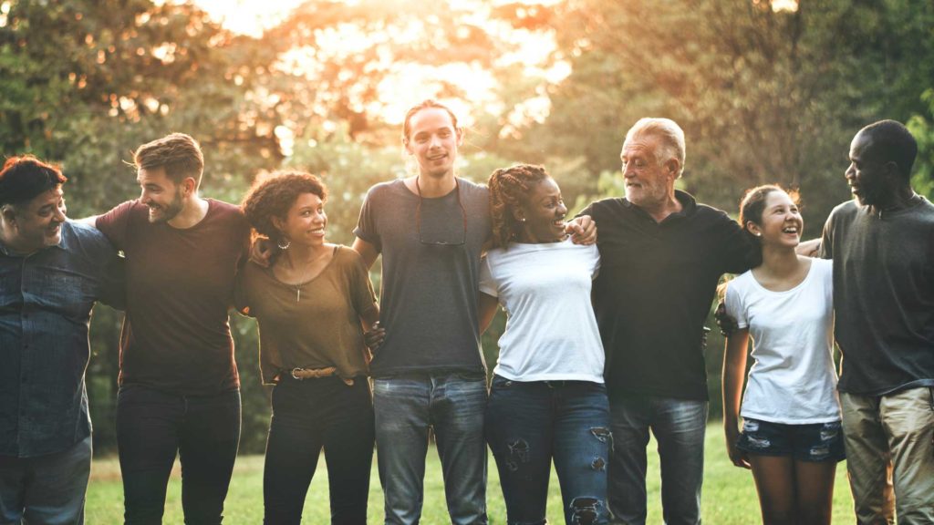 Cheerful diverse people huddling in the park